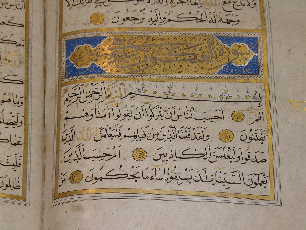 An open, illuminated classical Quran manuscript displaying Surah Al-Ankabut with ornate gold and blue calligraphy borders, representing Tajweed and recitation studies at Noori Quran Academy.